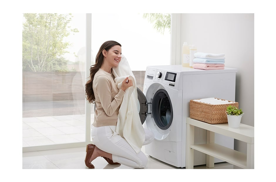 A person holding a towel in front of LG Dryer